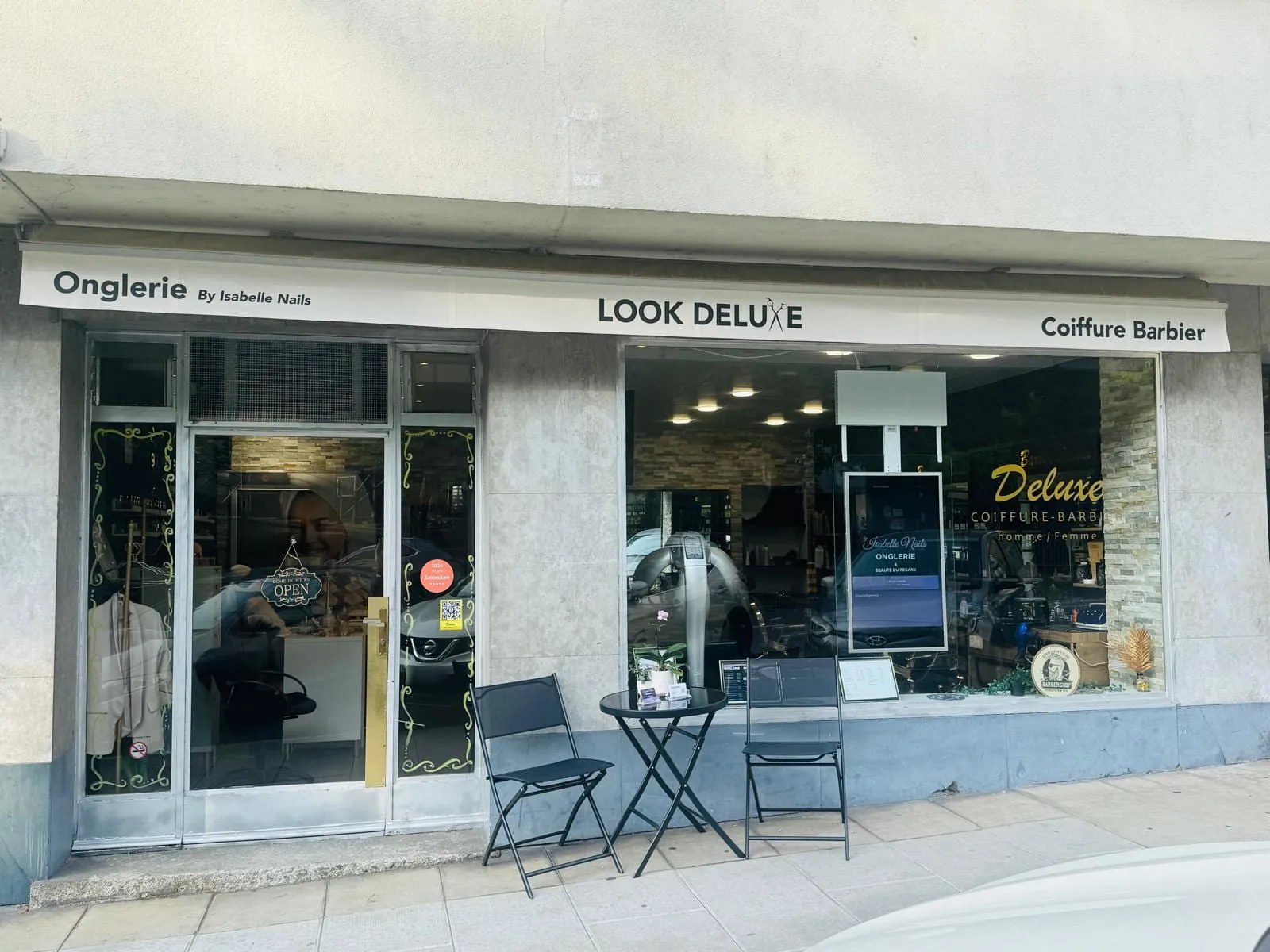 Entrée du salon Look Deluxe, avenue Théodore-Weber 7 aux Eaux-Vives : enseigne Look Deluxe entre l'onglerie Isabelle Nails et la vitrine coiffure-barbier