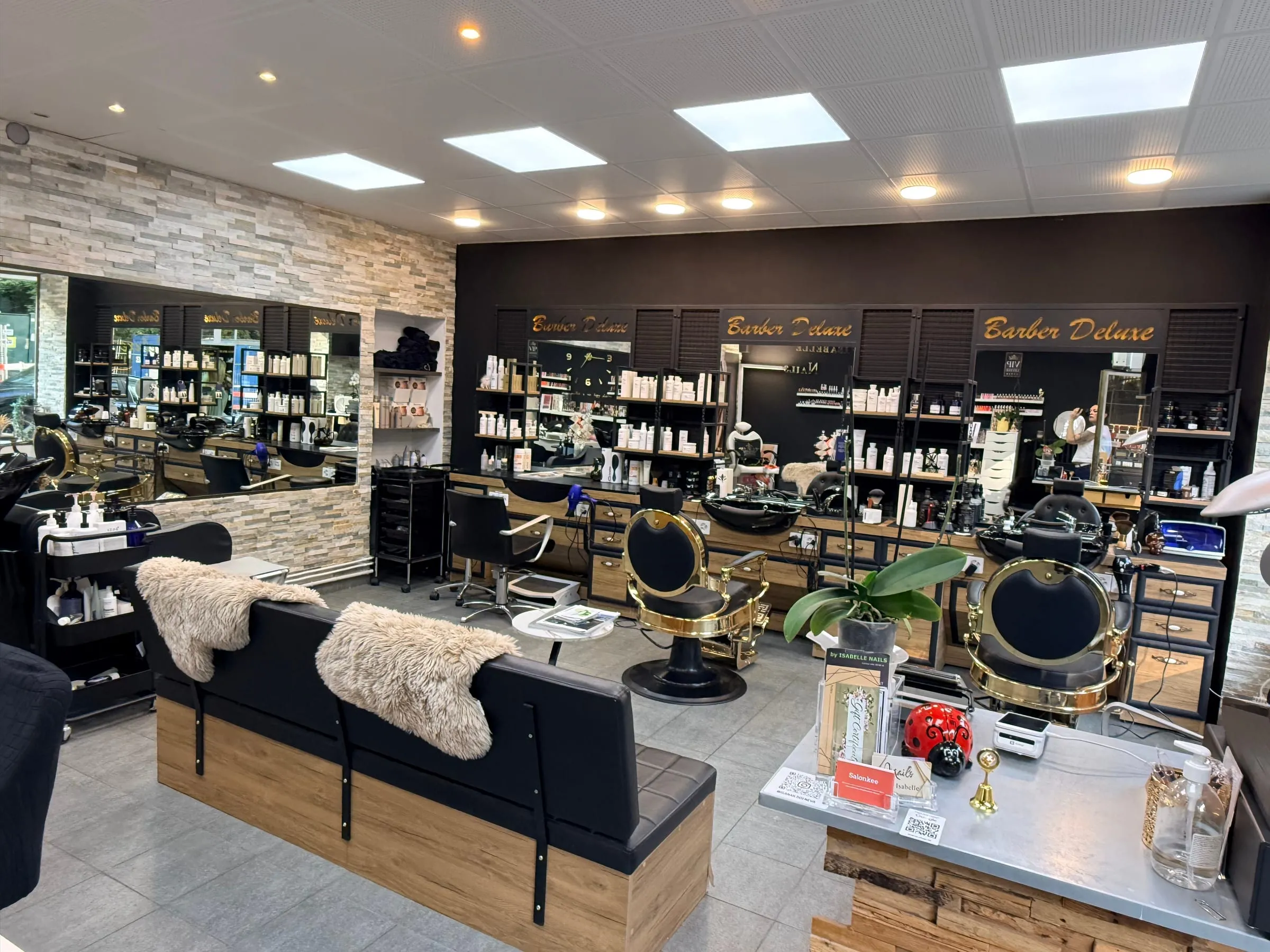 Espace coiffure homme & barbier de Look Deluxe aux Eaux-Vives : comptoir et postes barbier